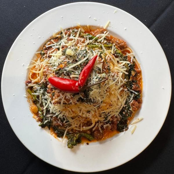 Marrelli's Italian Restaurant's spaghetti with meat sauce, greens, parmesan, and two red chili peppers.
