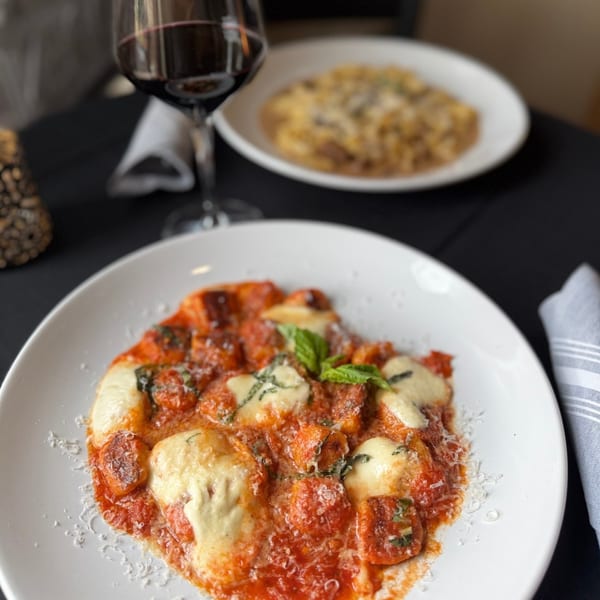 Marrelli's Italian Restaurant's gnocchi with tomato sauce, melted mozzarella, and basil, with wine and pasta.
